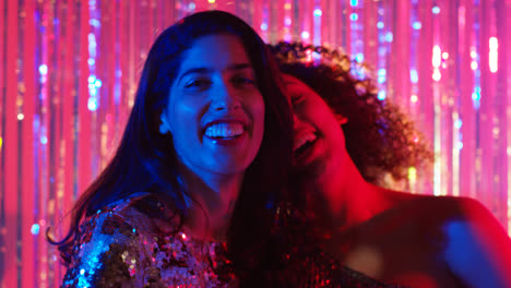 Portrait-Of-Two-Women-Friends-Having-Fun-Dancing-In-Nightclub-Bar-Or-Disco-With-Sparkling-Lights-3